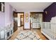 Charming Bedroom with a crib, dresser, and decorative accents against soft lavender and deep purple walls at 7706 S Crocker Ct, Littleton, CO 80120
