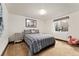 Comfortable bedroom with a plaid comforter, side table, and natural light from a window at 7706 S Crocker Ct, Littleton, CO 80120