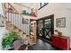 Inviting entryway featuring stone floors, staircase, and a beautiful front door with decorative 'X' design at 7706 S Crocker Ct, Littleton, CO 80120