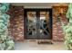 Close-up of the double front doors with glass and decorative 'X' design and brick surround at 7706 S Crocker Ct, Littleton, CO 80120