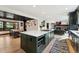 Open kitchen with a large island, a dining area, and a view of the living room fireplace at 7706 S Crocker Ct, Littleton, CO 80120