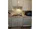 Functional kitchen featuring white cabinetry, a stainless steel sink, and essential appliances at 1233 Lansing St, Aurora, CO 80010
