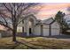 Two-story home boasts a three-car garage, stone accents, neutral color palette, and manicured lawn at 17158 Cornerstone Dr, Parker, CO 80134