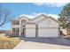 A two-story home with a three-car garage and stone accents, complimented by a manicured lawn at 17158 Cornerstone Dr, Parker, CO 80134