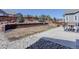 Landscaped backyard featuring a stone retaining wall, open lawn, and a concrete patio, perfect for outdoor enjoyment at 17718 Leisure Lake Dr, Monument, CO 80132
