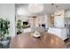 Open dining area with chandelier, wood floors, large round table, and view of kitchen, living room, and fireplace at 17718 Leisure Lake Dr, Monument, CO 80132
