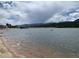 Scenic lake view with paddle boarders, mountain backdrop, and beach access, perfect for recreation at 17718 Leisure Lake Dr, Monument, CO 80132