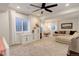 Bright living room with a ceiling fan, plush carpeting, and a large window with plenty of natural light at 17718 Leisure Lake Dr, Monument, CO 80132