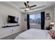 Bright main bedroom features a large window, ceiling fan, and a wall-mounted TV at 17718 Leisure Lake Dr, Monument, CO 80132