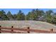 A distant bench sits atop a grassy mound in a beautiful setting with trees and fencing at 17718 Leisure Lake Dr, Monument, CO 80132