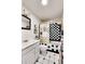 Cozy bathroom featuring a tub with checkered tile, white vanity, and decorative fixtures at 5011 Troy St, Denver, CO 80239