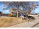 Charming two-story home with mature trees and a well-manicured front lawn at 5011 Troy St, Denver, CO 80239
