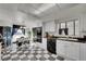 Elegant kitchen featuring black and white checkered floors, modern appliances and an adjacent dining area at 5011 Troy St, Denver, CO 80239