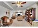 Spacious living room featuring plush seating, ceiling fan, and built-in shelving at 5011 Troy St, Denver, CO 80239