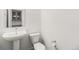 Minimalist half bathroom featuring a pedestal sink, toilet, and a mirrored cabinet at 9757 Ash Ln, Thornton, CO 80229