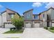 Modern townhome with stone accents, attached garage, and well-maintained landscaping under a blue sky at 9757 Ash Ln, Thornton, CO 80229