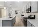 Bright kitchen with stainless appliances, sleek countertops, and wood-look flooring opening to the living area at 9757 Ash Ln, Thornton, CO 80229