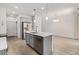 Bright kitchen featuring stainless steel appliances, an island with a sink, and wood-look flooring at 9757 Ash Ln, Thornton, CO 80229