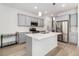 Modern kitchen with stainless steel appliances, quartz countertops, and a center island with seating at 9757 Ash Ln, Thornton, CO 80229