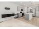 Open-concept kitchen and living area with modern appliances, island seating, and stylish light fixtures at 9757 Ash Ln, Thornton, CO 80229