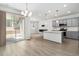 Modern kitchen with stainless appliances, a center island, and sliding door access to outdoor space at 9757 Ash Ln, Thornton, CO 80229