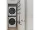 Laundry area equipped with a stackable washer and dryer, and storage racks at 9757 Ash Ln, Thornton, CO 80229