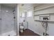Modern bathroom featuring a glass shower, toilet, vanity, shelving, and essential utilities at 6013 W 62Nd Ave, Arvada, CO 80033
