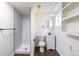 Modern bathroom featuring a glass shower, toilet, vanity, and storage shelving at 6013 W 62Nd Ave, Arvada, CO 80033