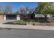 Charming home features brick accents, mature trees, an attached garage, and well-maintained landscaping at 6013 W 62Nd Ave, Arvada, CO 80033
