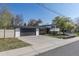 Charming two-story home with a well-maintained lawn, a large driveway, and mature trees enhancing the curb appeal at 6013 W 62Nd Ave, Arvada, CO 80033