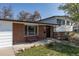 Brick-accented home featuring a cozy front bench, lush lawn, and a welcoming entrance at 6013 W 62Nd Ave, Arvada, CO 80033