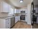 Bright kitchen features white cabinets, stainless steel appliances, stone countertops and modern fixtures at 6013 W 62Nd Ave, Arvada, CO 80033