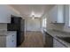 Well-lit kitchen features stainless steel appliances, granite countertops, and white cabinetry at 6013 W 62Nd Ave, Arvada, CO 80033