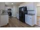 Bright kitchen features white cabinets, stone countertops, stainless steel appliances and wood-look floors at 6013 W 62Nd Ave, Arvada, CO 80033