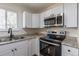 Bright kitchen features white cabinets, stone countertops, stainless steel appliances and modern fixtures at 6013 W 62Nd Ave, Arvada, CO 80033