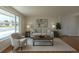 Bright living room showcasing a picture window, neutral decor, and hardwood floors at 6013 W 62Nd Ave, Arvada, CO 80033
