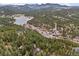 Scenic aerial view of a town with a lake and tree-covered mountains in the backdrop at 27891 Columbine Rd, Evergreen, CO 80439