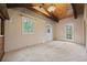 Generously sized bedroom with vaulted ceiling, multiple windows, and neutral carpet at 27891 Columbine Rd, Evergreen, CO 80439