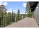 Outdoor deck features a black metal railing and gorgeous scenic views of the tree tops and hillside at 27891 Columbine Rd, Evergreen, CO 80439