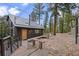 Charming home with a welcoming patio, stone accents, and mature trees at 27891 Columbine Rd, Evergreen, CO 80439