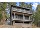 Multi-level home showcasing balconies, surrounded by lush green trees at 27891 Columbine Rd, Evergreen, CO 80439