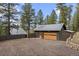 Detached garage and living quarters with gravel driveway and rock retaining wall at 27891 Columbine Rd, Evergreen, CO 80439