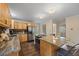 Open kitchen with wooden cabinets, stainless steel appliances, large eat-in island and tile backsplash at 27891 Columbine Rd, Evergreen, CO 80439