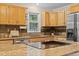 Kitchen area with granite countertops, wooden cabinets, stainless steel appliances, island and tile backsplash at 27891 Columbine Rd, Evergreen, CO 80439