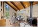 Charming living room featuring wood ceilings, a fireplace, and scenic views at 27891 Columbine Rd, Evergreen, CO 80439