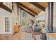 Cozy living room with vaulted wood ceilings, hardwood floors, large windows, and a modern wood-burning stove at 27891 Columbine Rd, Evergreen, CO 80439