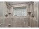 Luxurious tiled shower stall features dual shower heads and a glass block window that offers natural light at 27891 Columbine Rd, Evergreen, CO 80439