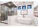 Bright bathroom features a glass-enclosed shower, soaking tub, and modern finishes at 3087 S Dexter Way, Denver, CO 80222