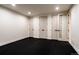 Versatile bonus room with black flooring, white walls, and multiple entry doors at 3087 S Dexter Way, Denver, CO 80222