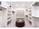 Spacious walk-in closet with ample shelving and a central ottoman for organization at 3087 S Dexter Way, Denver, CO 80222